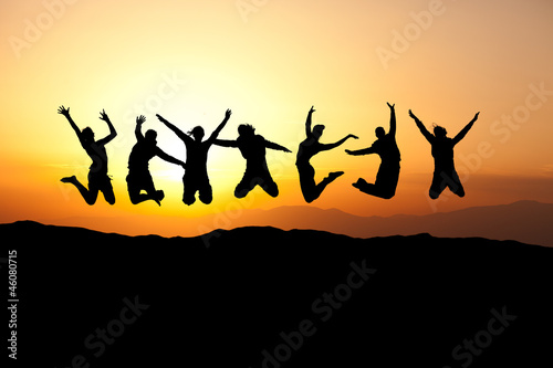 silhouette of teens jumping in sunset