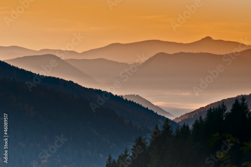 orange sunrise over the hazy autumn mountains