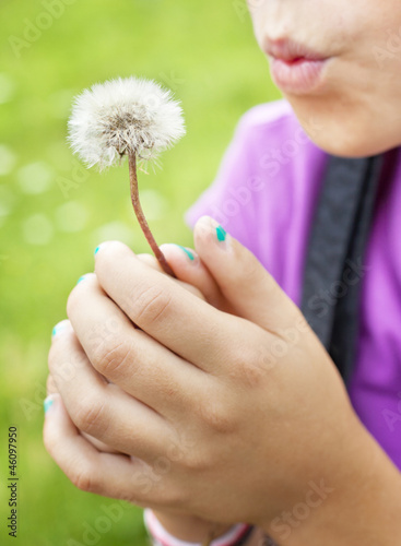 Girl blowing dandelion