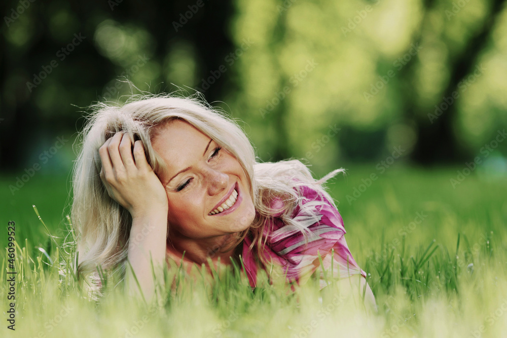 blonde lying on green grass blonde lying on green grass