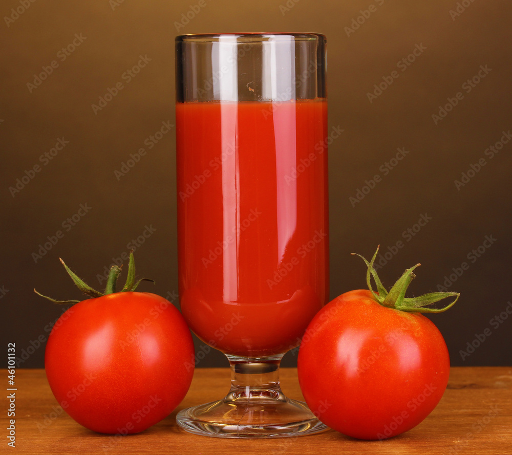 Tomato juice in glass on wooden table on brown background Tomato juice in glass on wooden table on brown background