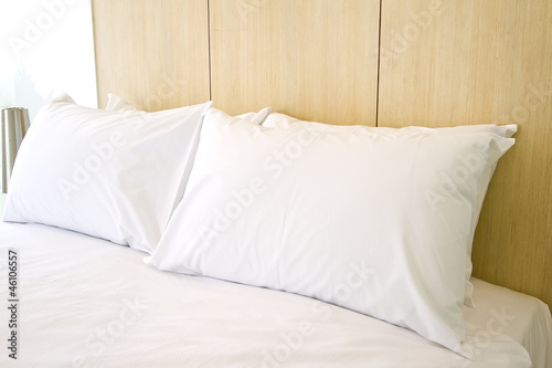 Clean white pillows and sheet on bed