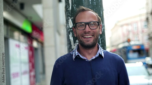 Portrait of young man standing on the street and smiling, steadi photo