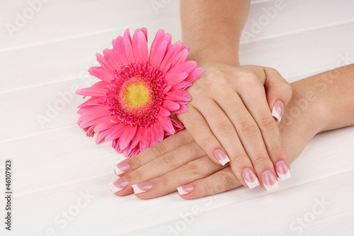 Woman hands with french manicure and flower