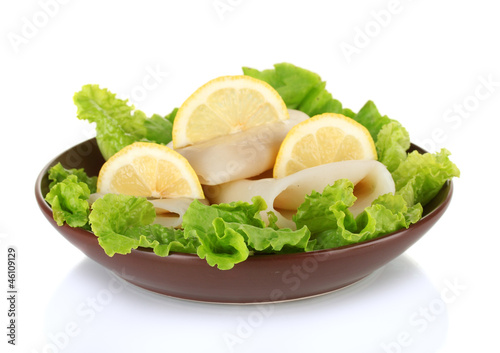 boiled squids with lettuce and lemon in the plate isolated