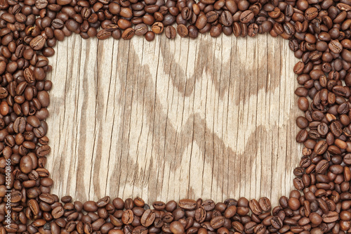 Frame of coffee beans on a wooden texture.