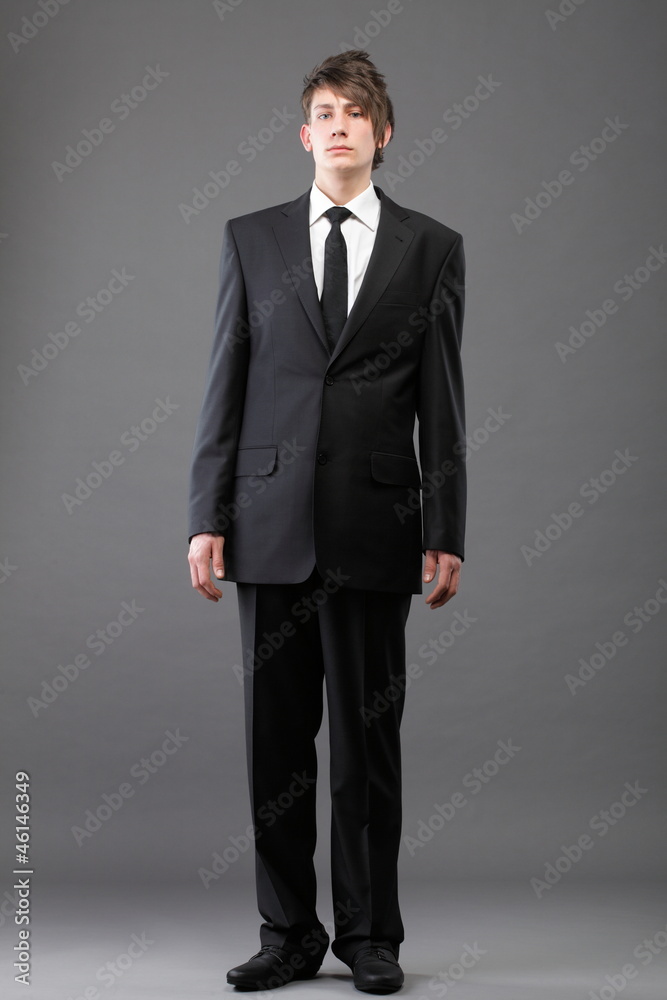 young businessman black suit casual tie on gray background young businessman black suit casual tie on gray background
