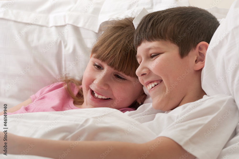 Smiling children in bed playing. Close-up. Smiling children in bed playing. Close-up.