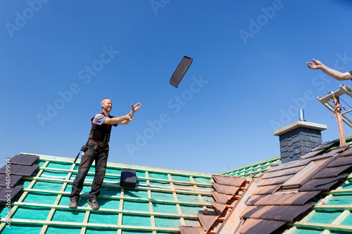 zwei dachdecker werfen dachziegel photo