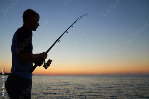 Fisherman fishes at the sunset
