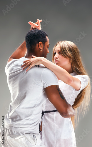Young couple dances Caribbean Salsa, studio shot
