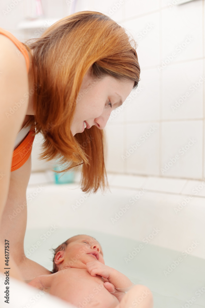 Naklejka premium Mother bathes newborn baby