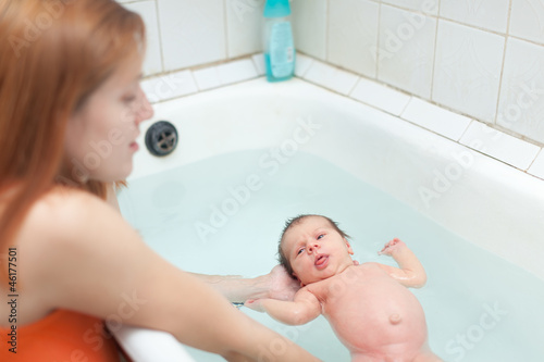 Mother bathes newborn