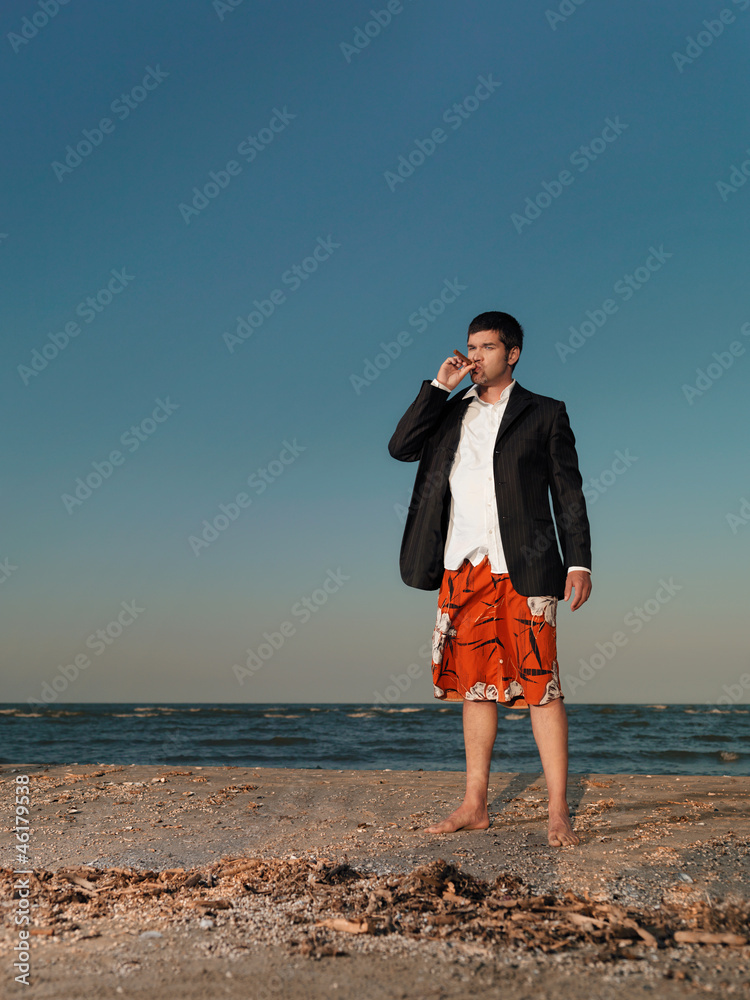 confident businessman smoking cigar on sea shore confident businessman smoking cigar on sea shore