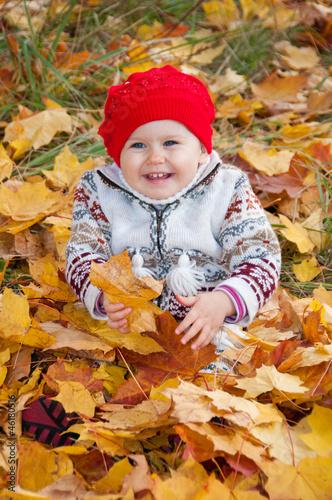 Little cute baby girl on a background of autumn leaves