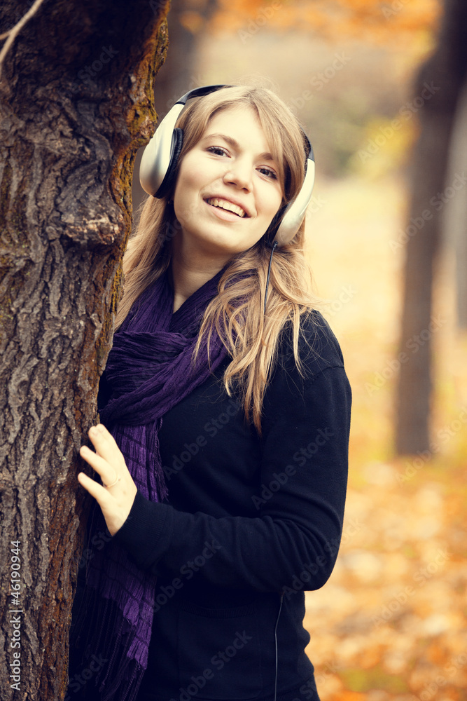 Portrait of girl with headphones at outdoor. Autumn.