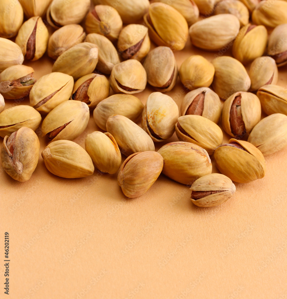 tasty pistachio nuts, on beige background tasty pistachio nuts, on beige background