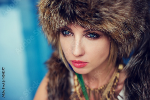 Fashion portrait of a woman in fur next to the swimming pool.