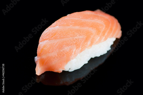 Sushi with salmon on a black plate, horizontal shot