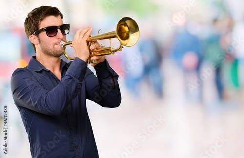 A Young Man Blowing A Trumpet