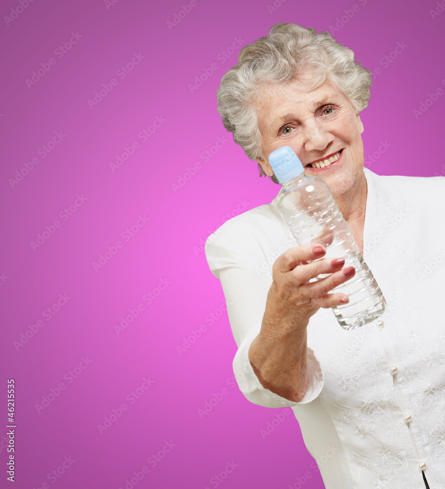 portrait of healthy senior woman holding a water bottle over pur portrait of healthy senior woman holding a water bottle over pur