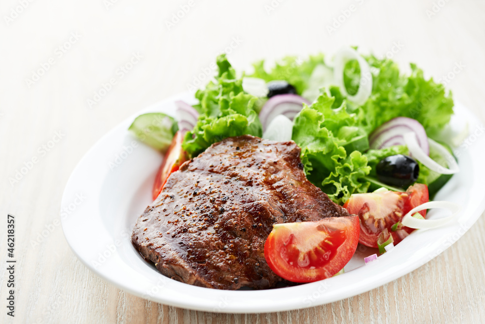 Grilled steak with fresh vegetables on a plate Grilled steak with fresh vegetables on a plate