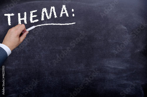 Mann schreibt Thema an eine Tafel