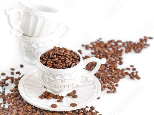 Coffee beans in a cup on white background