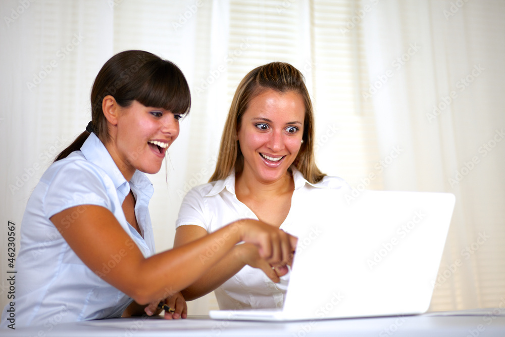 Surprised adult businesswomen reading on laptop Surprised adult businesswomen reading on laptop