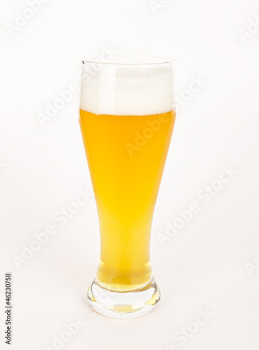 A glass with unfiltered beer on white