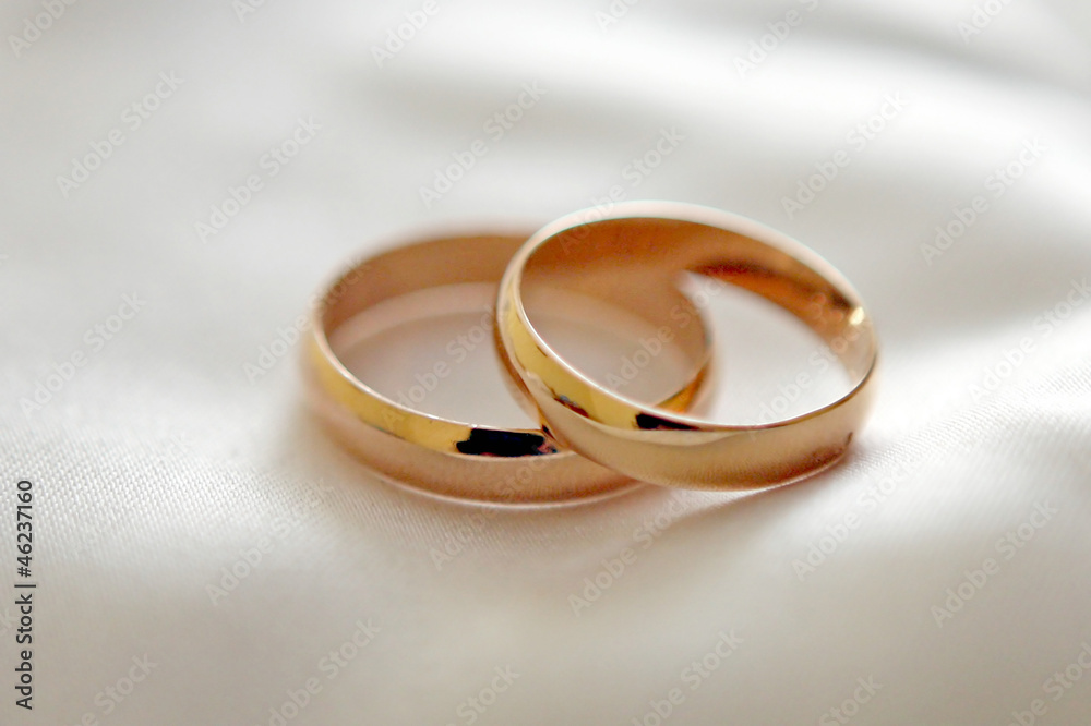 Two wedding rings with white flower in the background, wedding p Two wedding rings with white flower in the background, wedding p