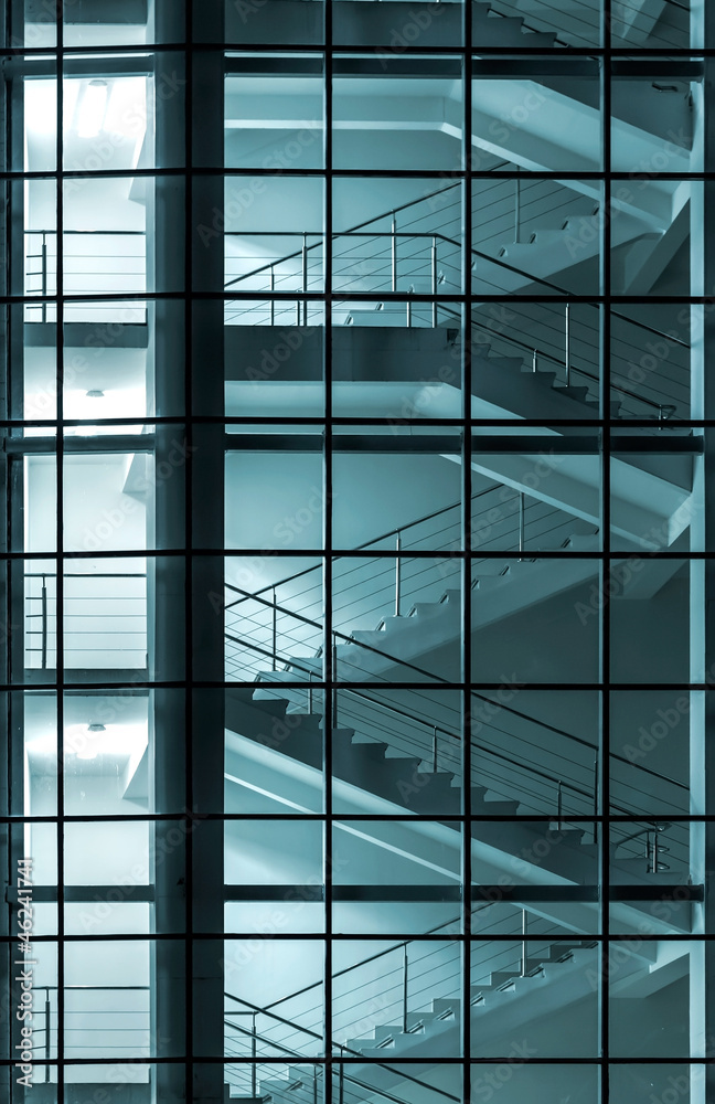 Modern building facade with staircase behind glass wall Modern building facade with staircase behind glass wall