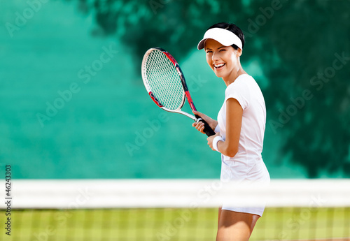 Pretty sportswoman with racquet at the tennis court