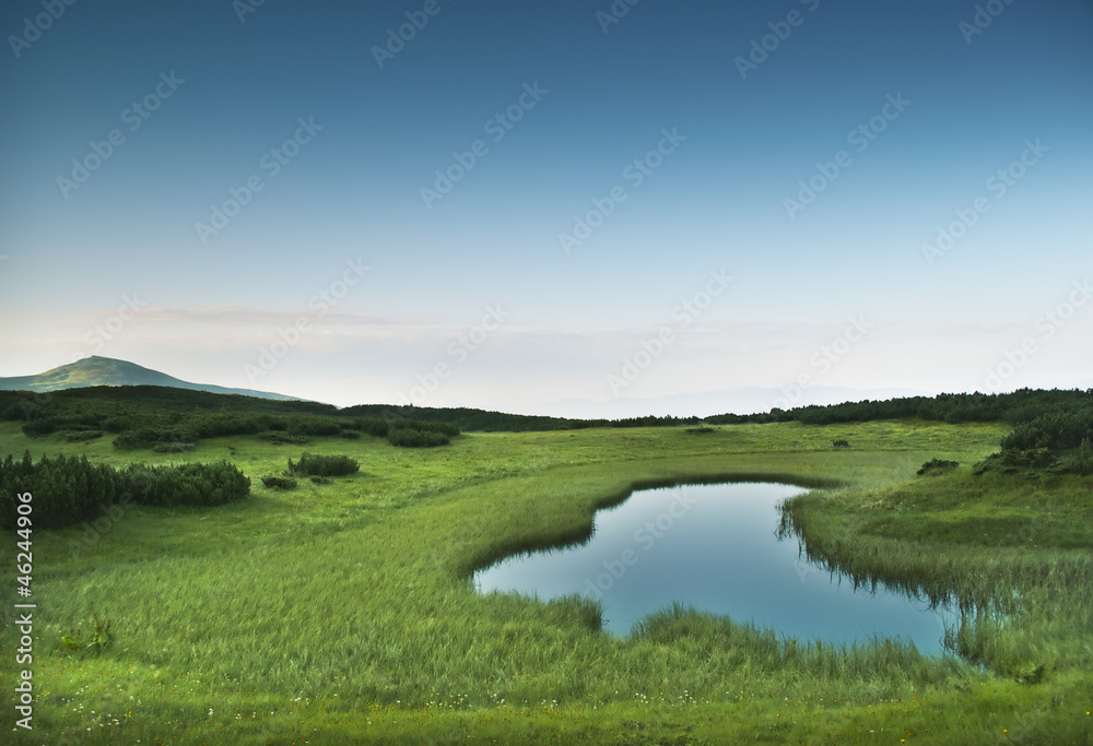 Morning near small mountainous pond