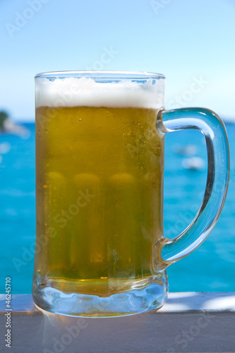 cold beer with sea and sky in the background