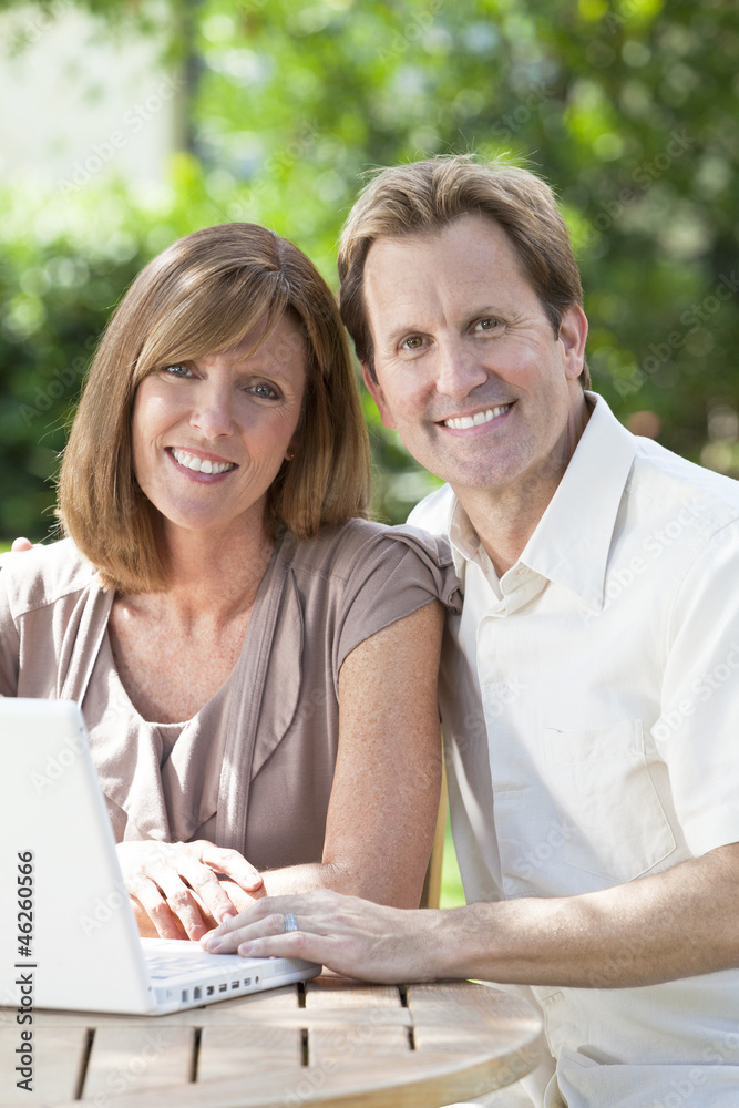 Man & Woman Couple Using Laptop Computer In Garden Man & Woman Couple Using Laptop Computer In Garden