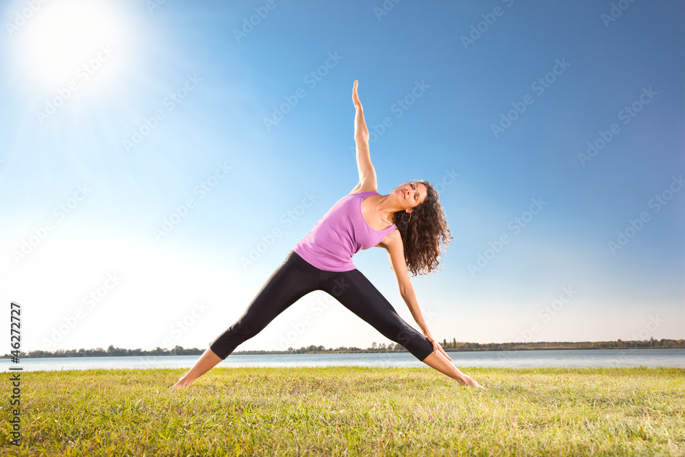 Beautiful young woman doing yoga exercise on green grass Beautiful young woman doing yoga exercise on green grass