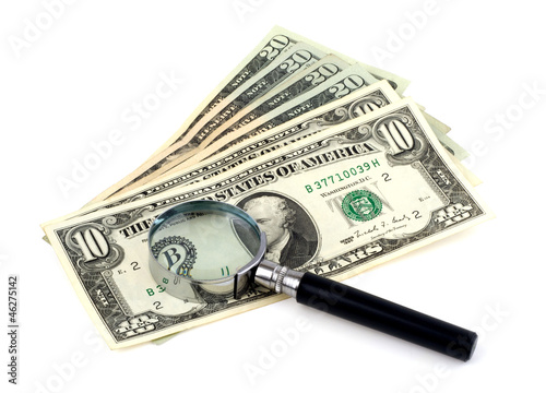 dollars with a magnifying glass on a white background