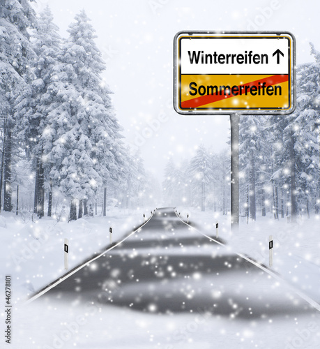 Schneefahrbahn mit Ortsschild Winterreifen