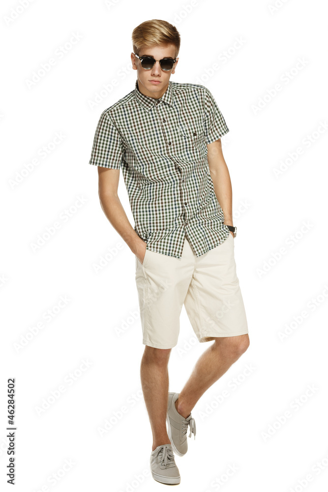 Handsome male in shorts and sunglasses posing in full length Handsome male in shorts and sunglasses posing in full length