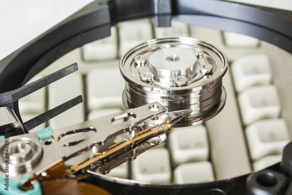 Close up of opened hard disk drive with keyboard reflection Close up of opened hard disk drive with keyboard reflection