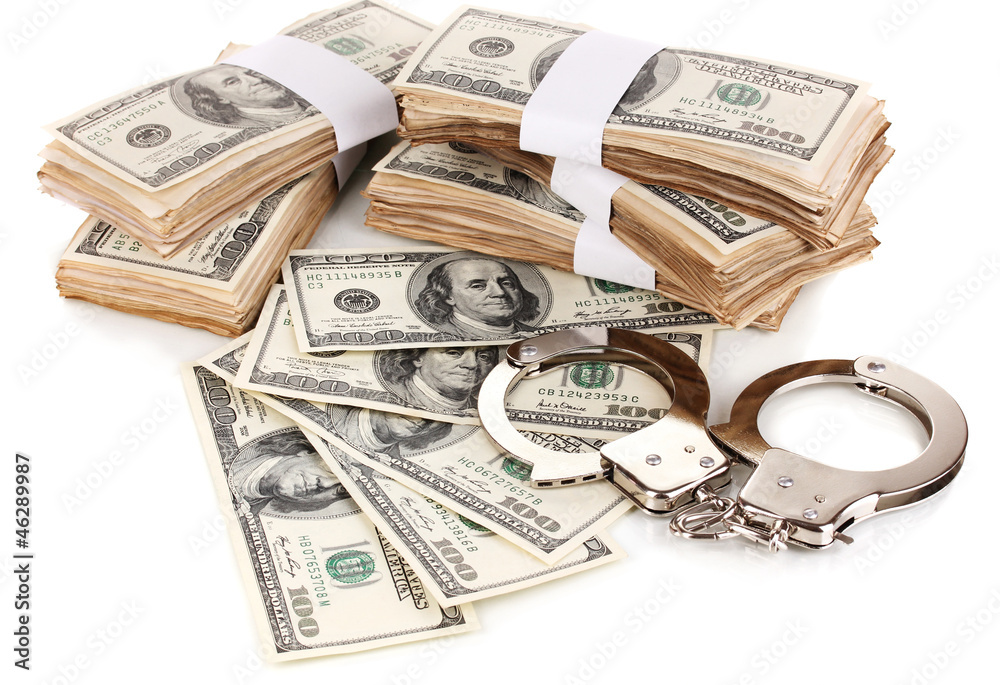Handcuffs and packs of dollars isolated on white Handcuffs and packs of dollars isolated on white