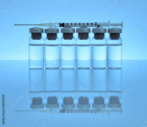 Vials of medications with syringe and needle.