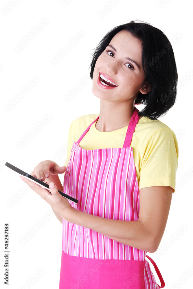 Young woman in pink apron using tablet computer Young woman in pink apron using tablet computer