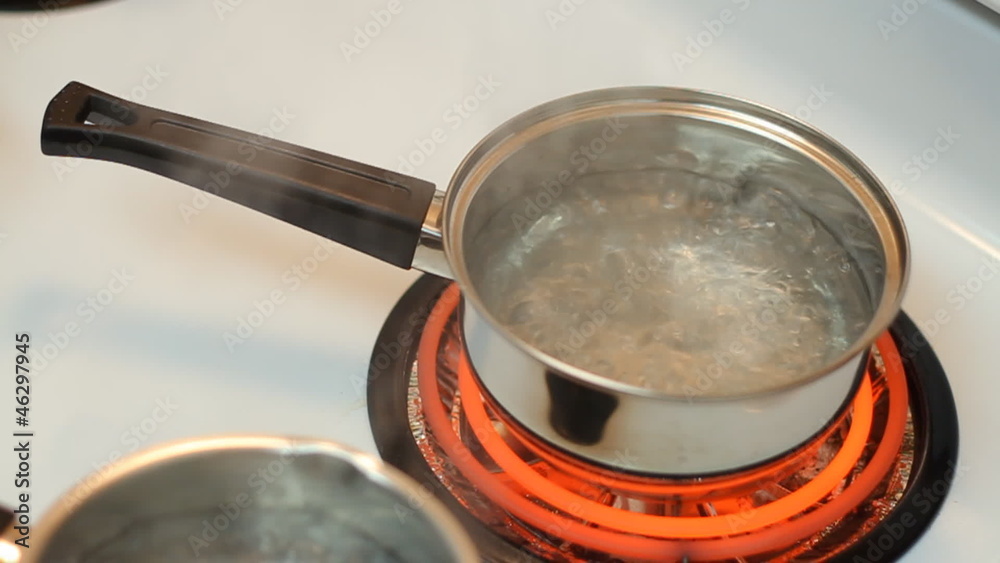 Pot full of boiling water on the electric stove.