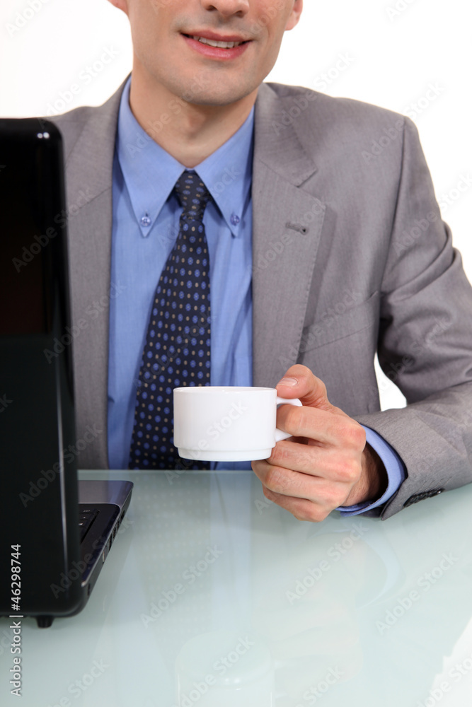 Businessman sat at laptop with morning coffee Businessman sat at laptop with morning coffee