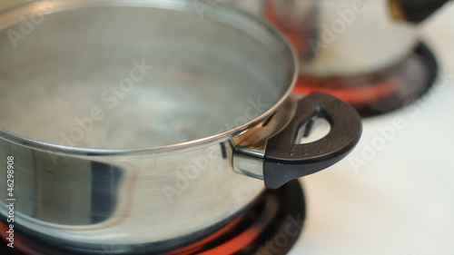 Pot full of boiling water on the electric stove.