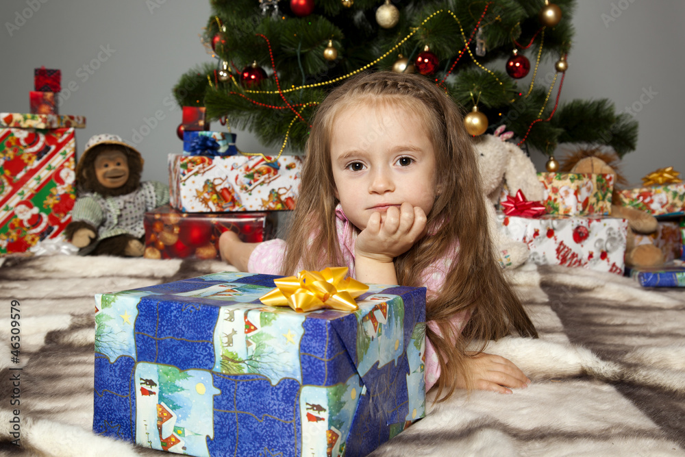 The girl with a gift under the Christmas tree