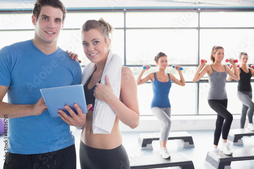 Trainer and woman smiling together during aerobics class