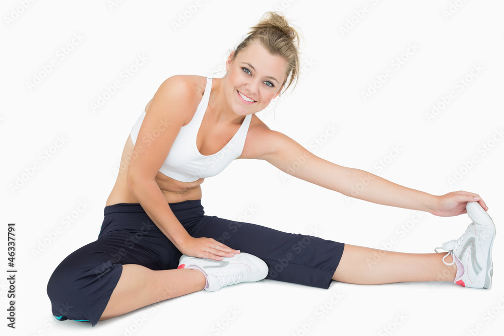 Woman sitting and stretching while smiling Woman sitting and stretching while smiling